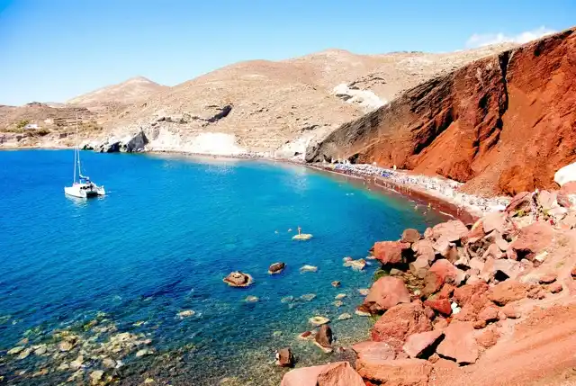 Η Κόκκινη Παραλία της Σαντορίνης, με κόκκινους βράχους πάνω από γαλάζιο κόλπο