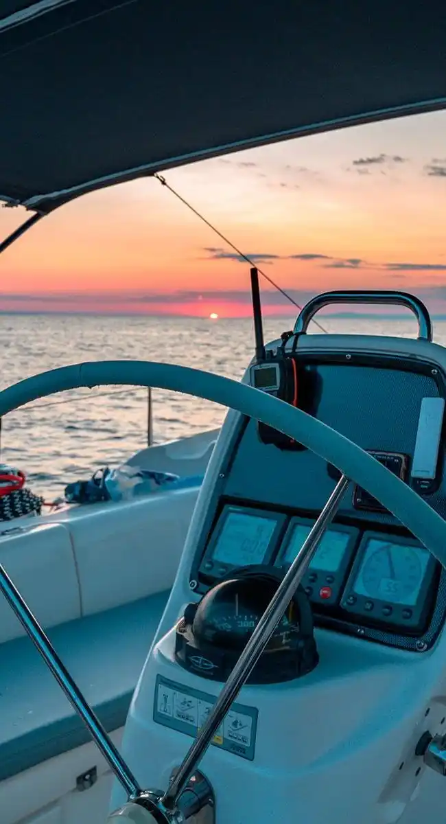 Helm of a sailing yacht in the cockpit at sunset