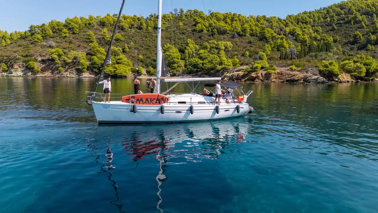 Το Bavaria 40 Babasails αγκυροβολημένο σε ήσυχο κολπίσκο με πεύκα στη Σιθωνία, με επισκέπτες στο κατάστρωμα
