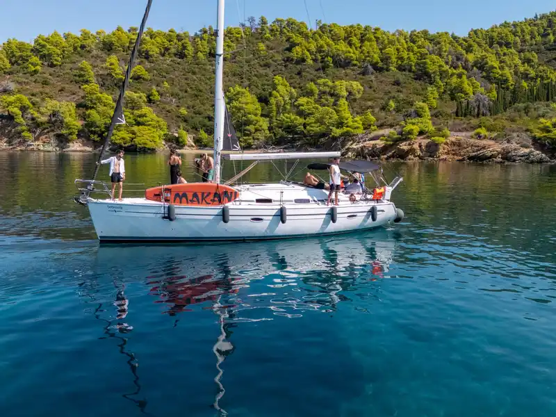 Το Bavaria 40 Babasails αγκυροβολημένο σε ήσυχο κολπίσκο με πεύκα στη Σιθωνία, με επισκέπτες στο κατάστρωμα
