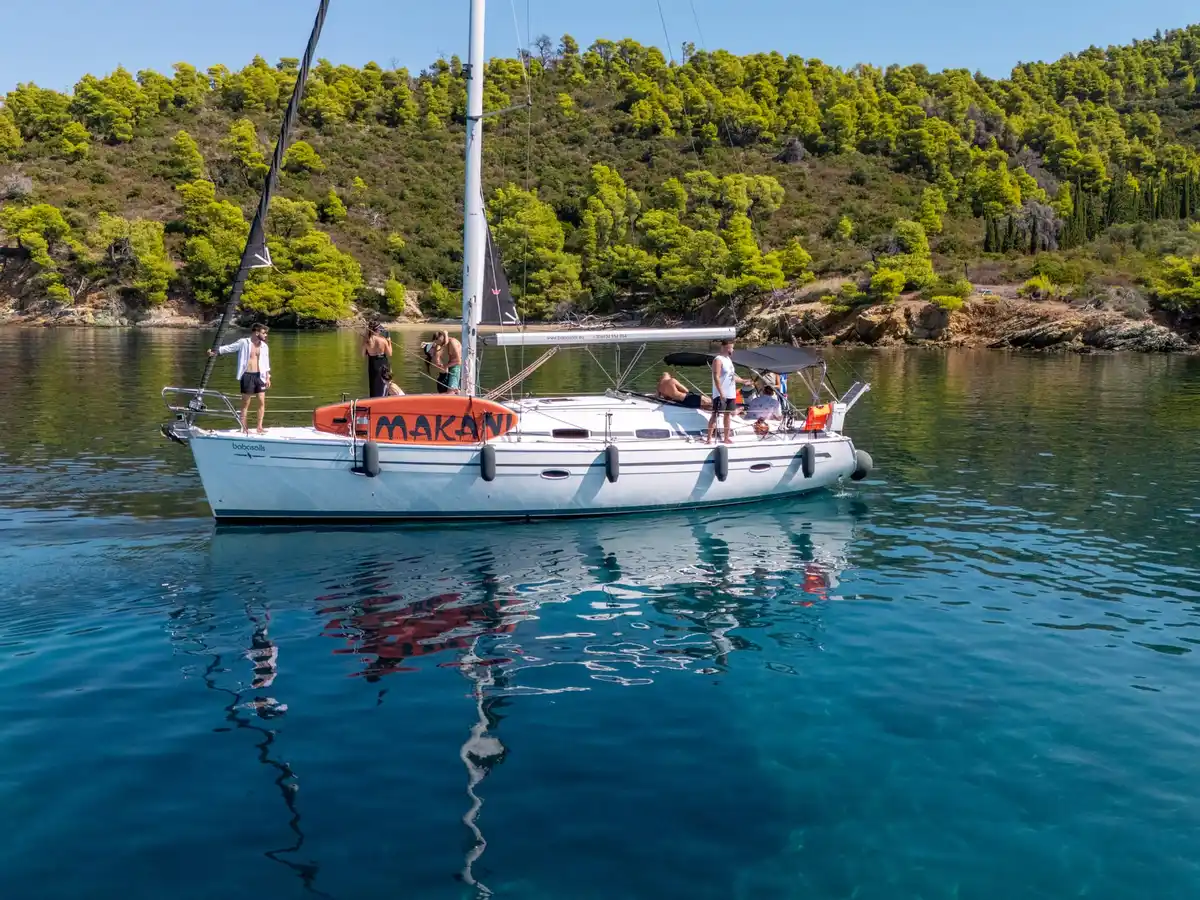 Το Bavaria 40 Babasails αγκυροβολημένο σε ήσυχο κολπίσκο με πεύκα στη Σιθωνία, με επισκέπτες στο κατάστρωμα