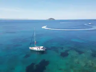 Το Bavaria 40 Babasails από ψηλά, σε έναν φαρδύ τιρκουάζ κόλπο στη Σιθωνία