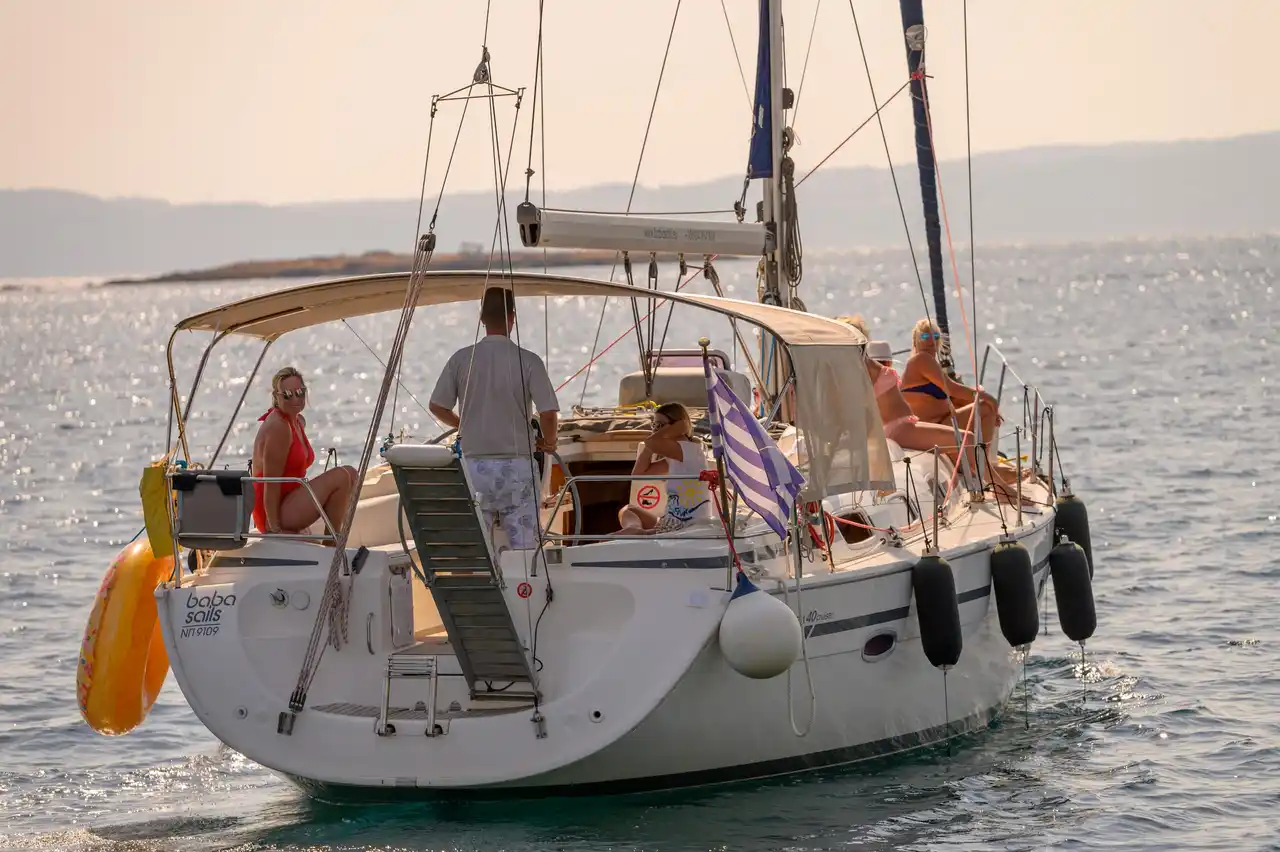 Η πρύμνη του Bavaria 40 Babasails στο χρυσό απογευματινό φως, με επισκέπτες στο κόκπιτ