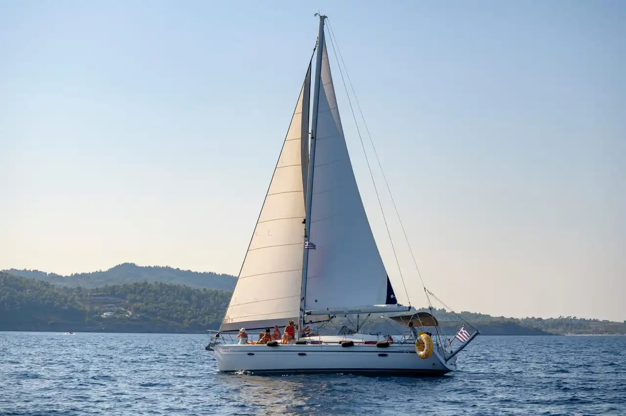 Το Bavaria 40 Babasails με όλα τα πανιά ανοιχτά, κατά μήκος μιας δασωμένης ακτής