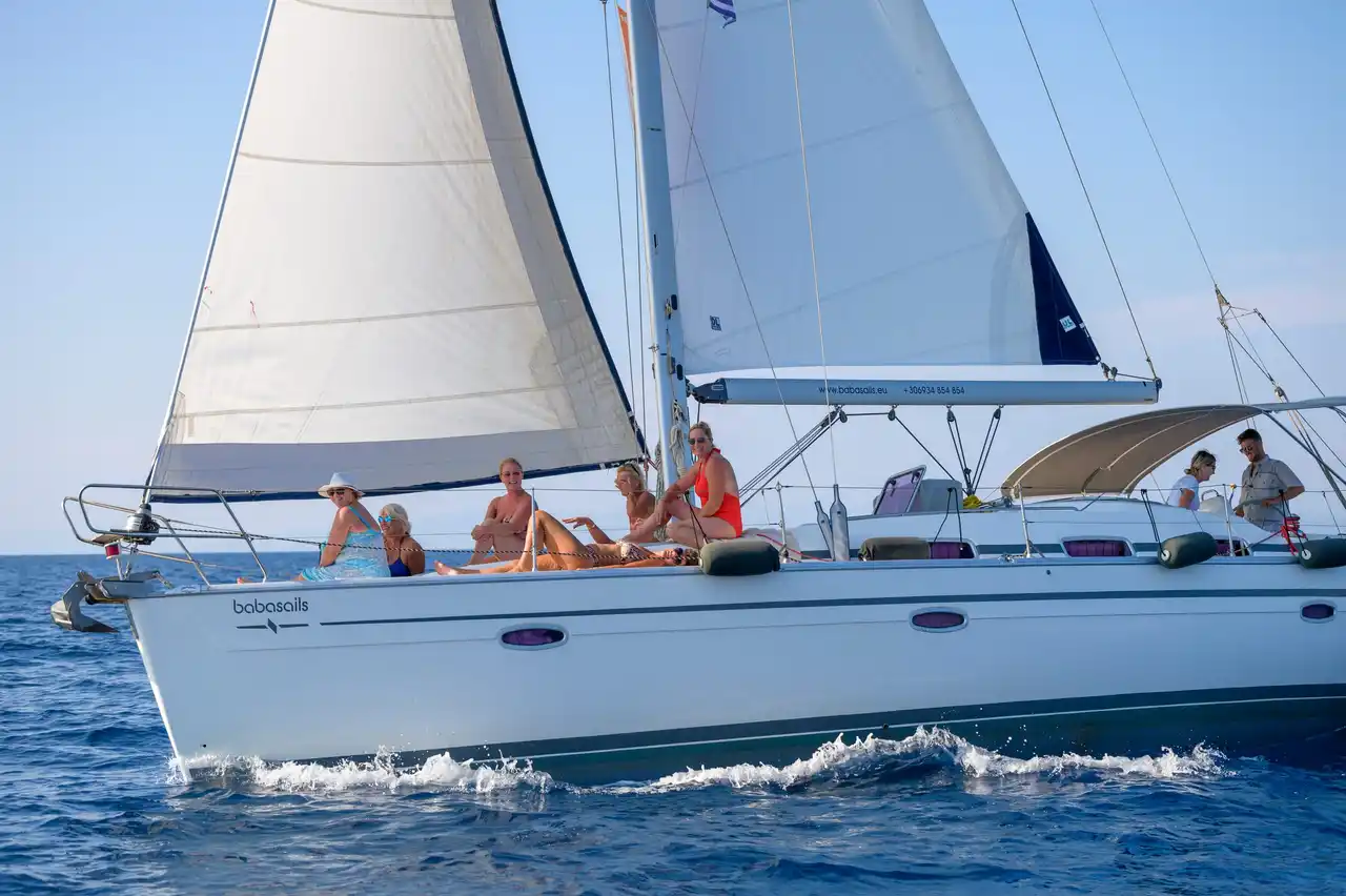 Το Bavaria 40 Babasails με τα πανιά ανοιχτά και επισκέπτες καθισμένους στο κατάστρωμα