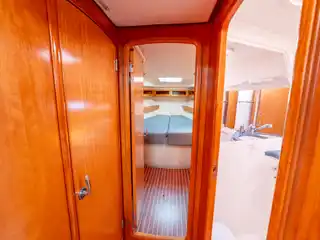 Μέσα στο Bavaria 46 Fox: ανοιχτή πόρτα καμπίνας με διπλό κρεβάτι και δίπλα το μπάνιο