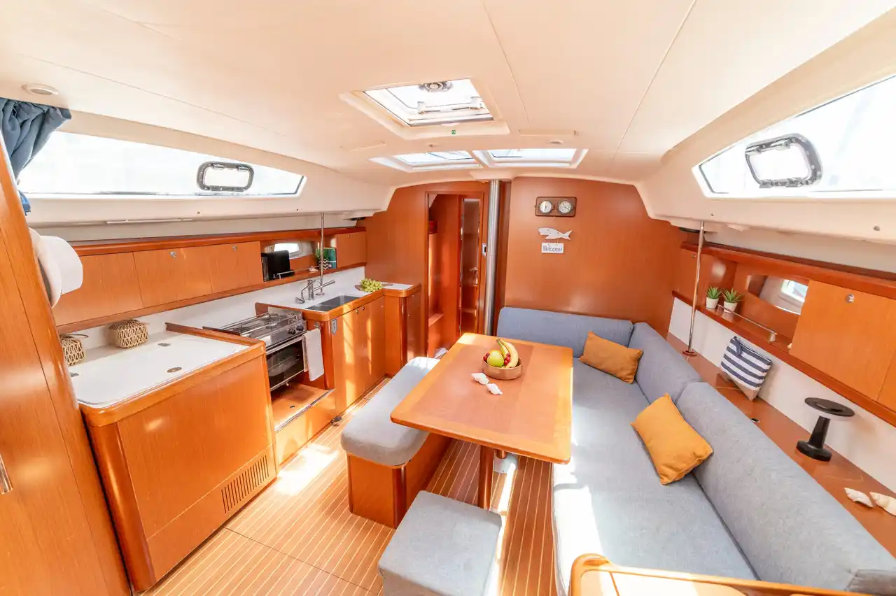 Το σαλόνι του Beneteau 43 Starcat, με καναπέδες γύρω από το τραπέζι και την κουζίνα αριστερά