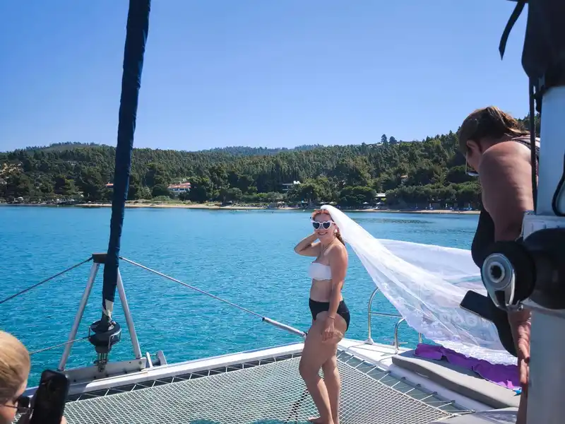 Η μέλλουσα νύφη με πέπλο που ανεμίζει ποζάρει στα δίχτυα ενός καταμαράν