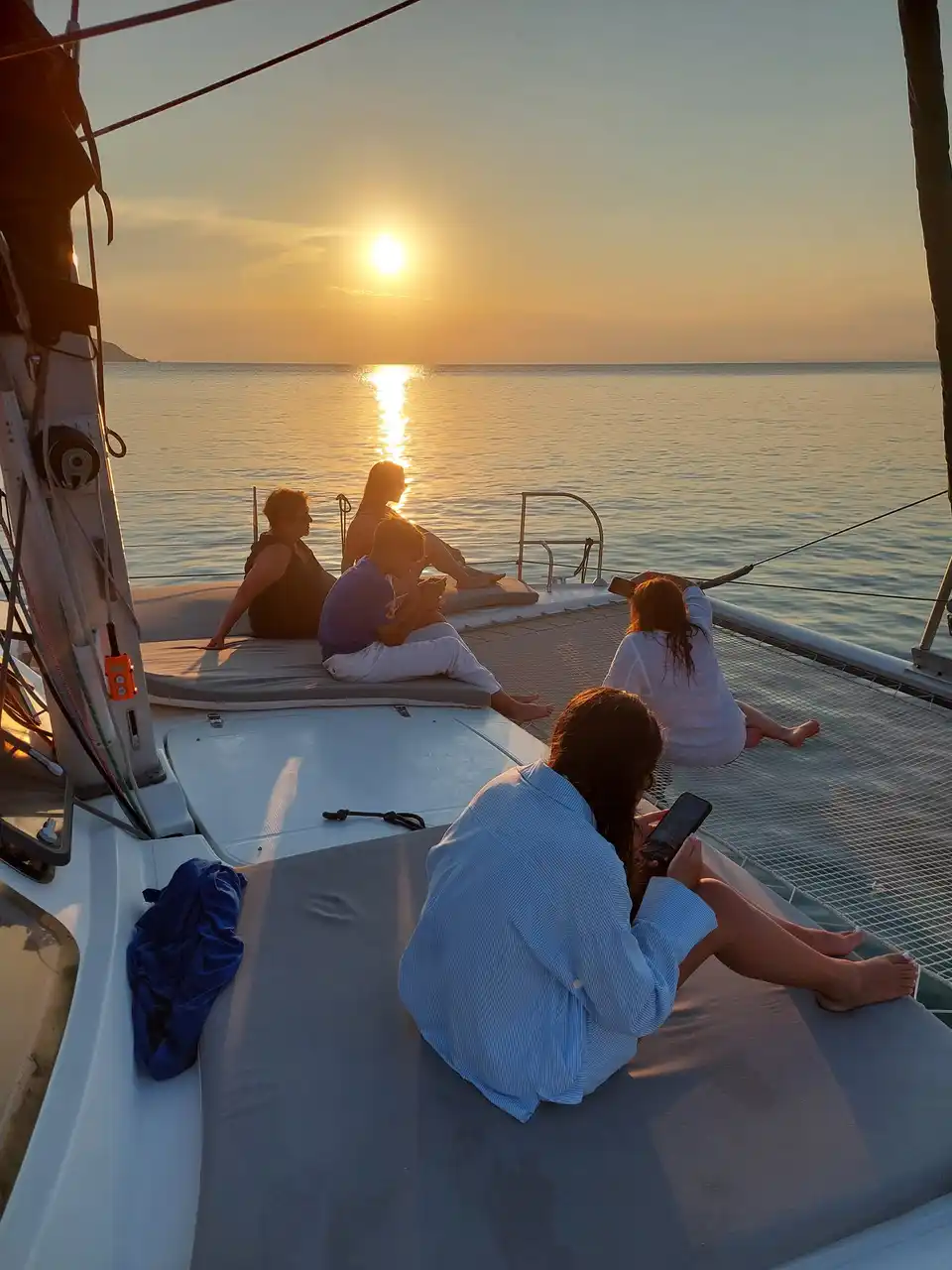 Guests watching the sunset from the bow of a catamaran