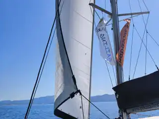 Guests lying on a catamaran’s bow as it sails under the genoa