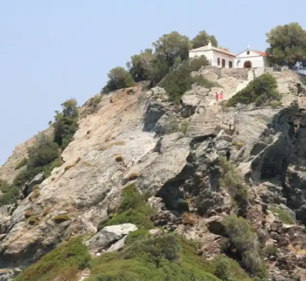 The white chapel of Agios Ioannis at Kastri, Skopelos, on top of a steep rocky hill with pines