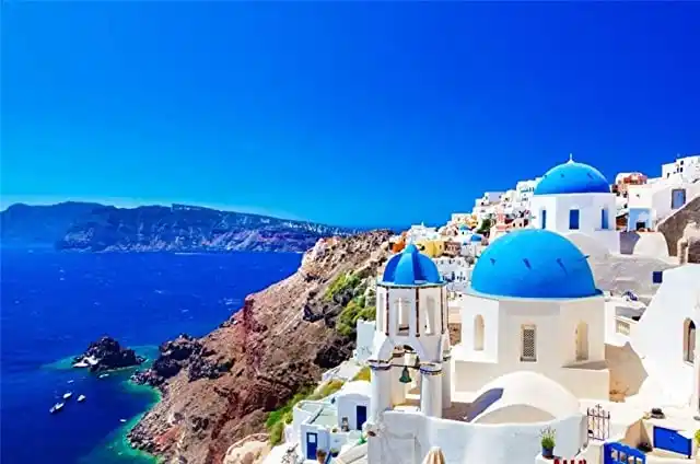 Γαλάζιοι τρούλοι και άσπρα σπίτια στην Οία, πάνω από την καλντέρα της Σαντορίνης