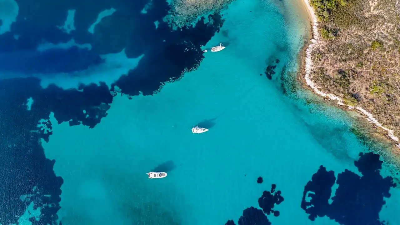 Τρία σκάφη αγκυροβολημένα πάνω από ρηχά τιρκουάζ νερά στον Διάπορο
