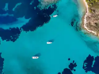 Τρία σκάφη αγκυροβολημένα πάνω από ρηχά τιρκουάζ νερά στον Διάπορο