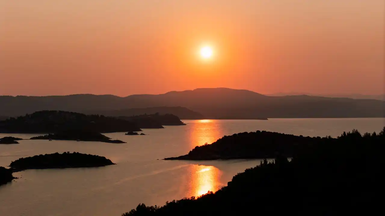 Sun setting over the islets of Diaporos, reflected on calm water