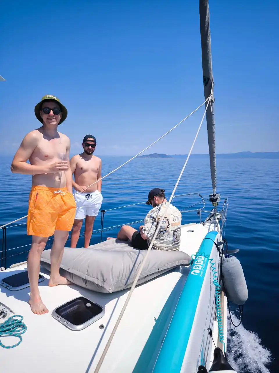 Φίλοι όρθιοι στην πλώρη ιστιοπλοϊκού, σε ήρεμη γαλάζια θάλασσα