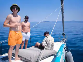 Φίλοι όρθιοι στην πλώρη ιστιοπλοϊκού, σε ήρεμη γαλάζια θάλασσα