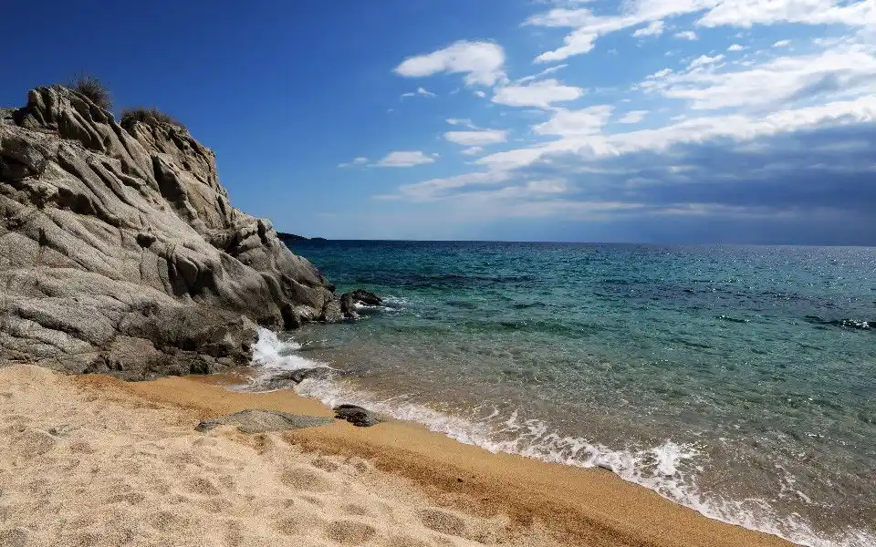 Sandy beach with pale rocks and turquoise sea in Halkidiki