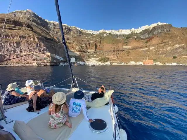 Επιβάτες στην πλώρη καταμαράν, κάτω από τους βράχους των Φηρών
