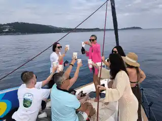 Friends toasting on the bow of a sailing yacht off Kassandra