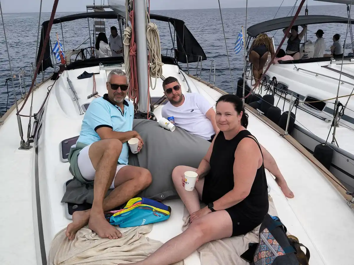 Guests relaxing on the bow of a sailing yacht beside another yacht off Kassandra