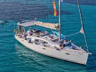 Guests swimming from a sailing yacht at anchor in bright turquoise water