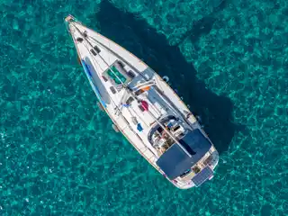 Ιστιοπλοϊκό στην άγκυρα πάνω από τιρκουάζ νερά με κυματάκια, από ψηλά