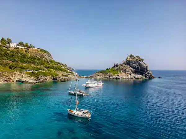 Sailing yachts anchored off the rock of Agios Ioannis on Skopelos