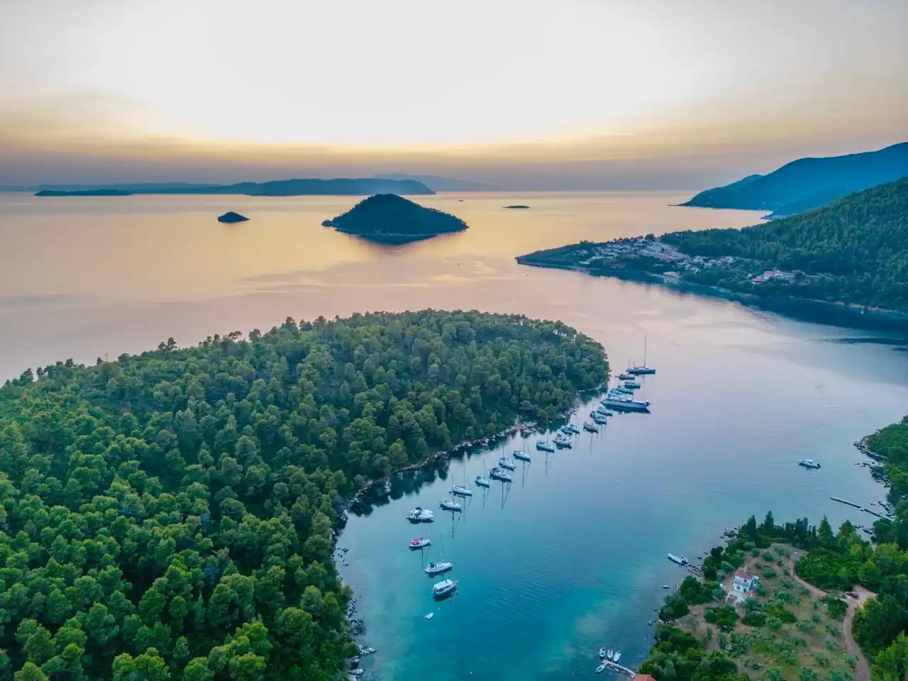 Panormos bay on Skopelos with anchored yachts in soft evening light, seen from above