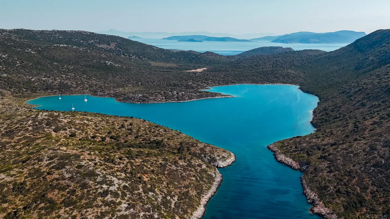 Μακρύς τιρκουάζ κολπίσκος ανάμεσα σε ξερούς λόφους, από ψηλά, Σποράδες
