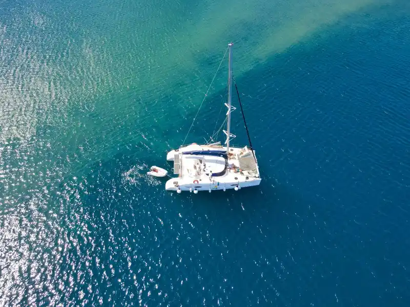 Catamaran on deep blue water, seen from above