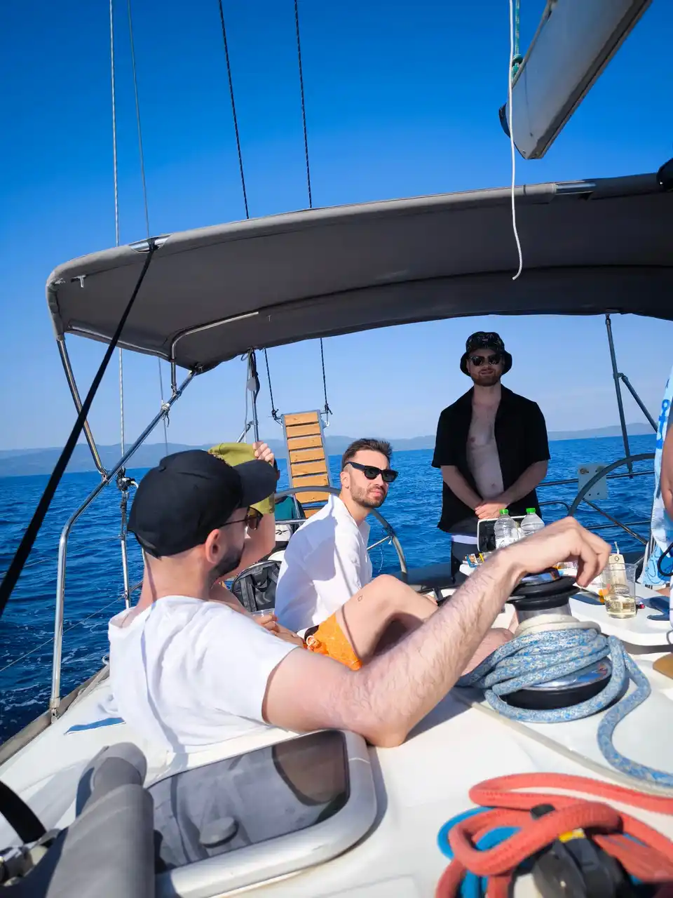 Friends relaxing in a sailing yacht’s cockpit on open water