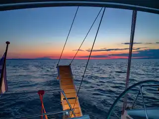 Swim ladder and wake at a sailing yacht’s stern at dusk